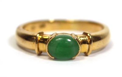 Lot 671 - A yellow metal ring set oval cabochon green...