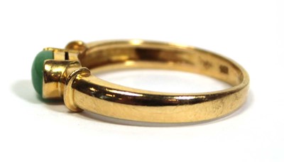 Lot 671 - A yellow metal ring set oval cabochon green...