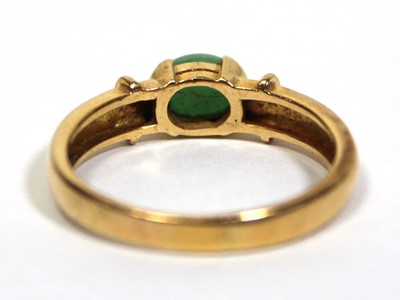 Lot 671 - A yellow metal ring set oval cabochon green...