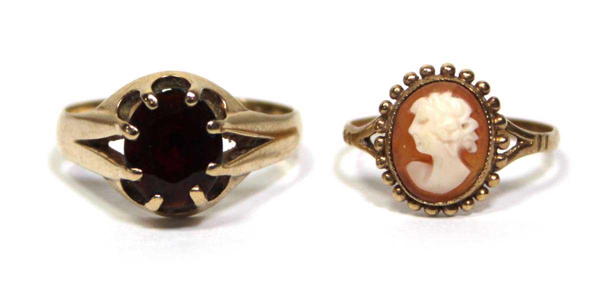 Lot 686 - A 9ct yellow gold ring set oval garnet in an...