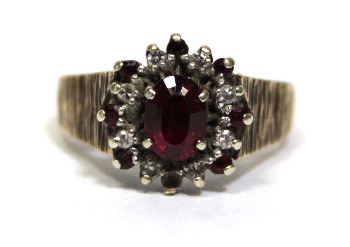 Lot 687 - A 9ct yellow gold cluster ring set oval garnet...
