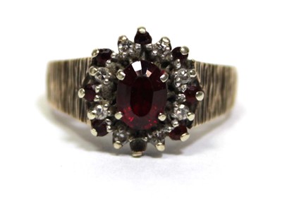 Lot 687 - A 9ct yellow gold cluster ring set oval garnet...