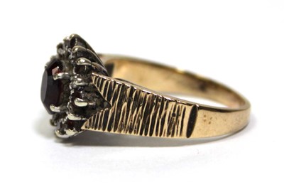 Lot 687 - A 9ct yellow gold cluster ring set oval garnet...