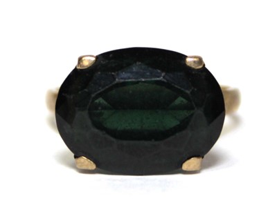 Lot 688 - A 9ct yellow gold dress ring set oval green...