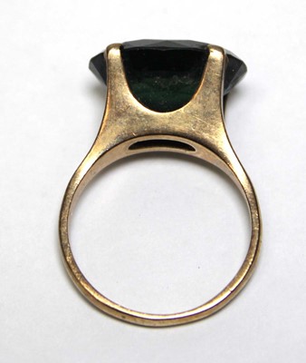 Lot 688 - A 9ct yellow gold dress ring set oval green...