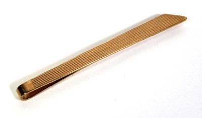 Lot 707 - A 9ct yellow gold engine turned tie clip,...