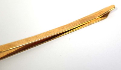 Lot 707 - A 9ct yellow gold engine turned tie clip,...