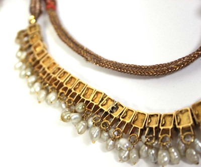 Lot 710 - An Indian cord and yellow gold necklace...