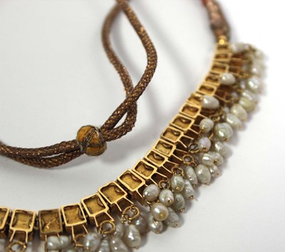 Lot 710 - An Indian cord and yellow gold necklace...