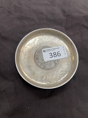 Lot 386 - An oriental white metal dish with Chinese coin...