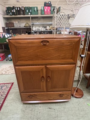 Lot 91 - A medium Ercol cabinet with pull down flap...