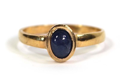 Lot 759 - A yellow metal ring set cabochon sapphire in a...