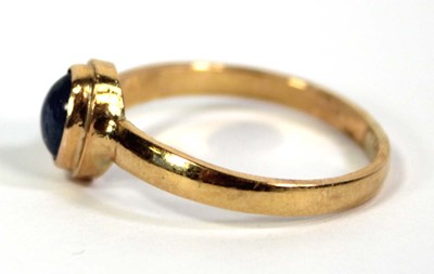 Lot 759 - A yellow metal ring set cabochon sapphire in a...