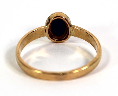 Lot 759 - A yellow metal ring set cabochon sapphire in a...
