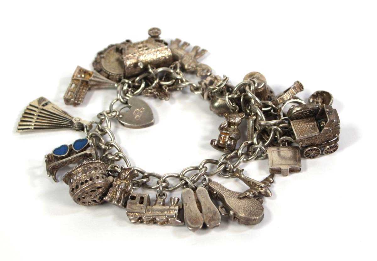 Lot 782 - A silver curblink bracelet with heart shaped...