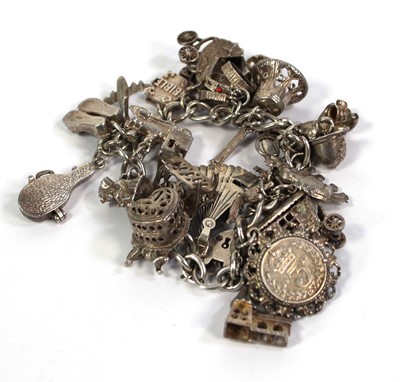 Lot 782 - A silver curblink bracelet with heart shaped...