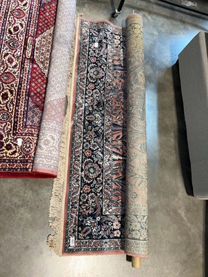 Lot 1651 - Tasseled figured and bordered rug on a pink...