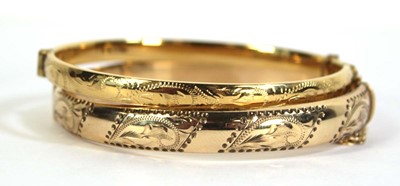 Lot 793 - A 9ct yellow gold hinged bracelet with scroll...